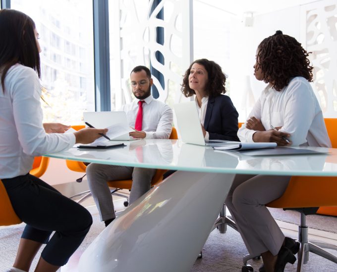 Business leader interviewing job candidate. Business man and women sitting at conference table, using laptops and talking. Discussion agreement concept